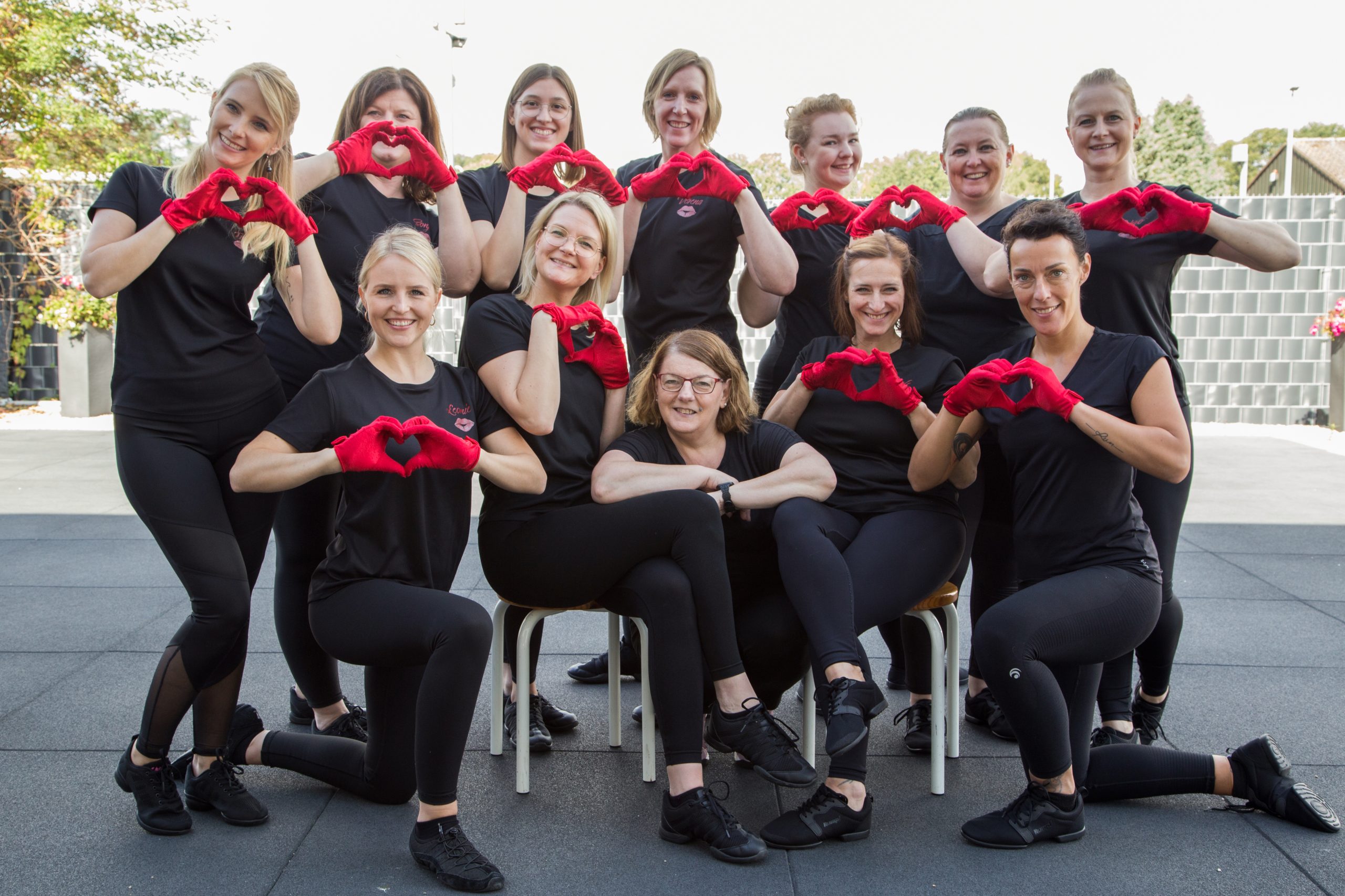 Eleven Kisses zeigen Herz mit roten Handschuhen